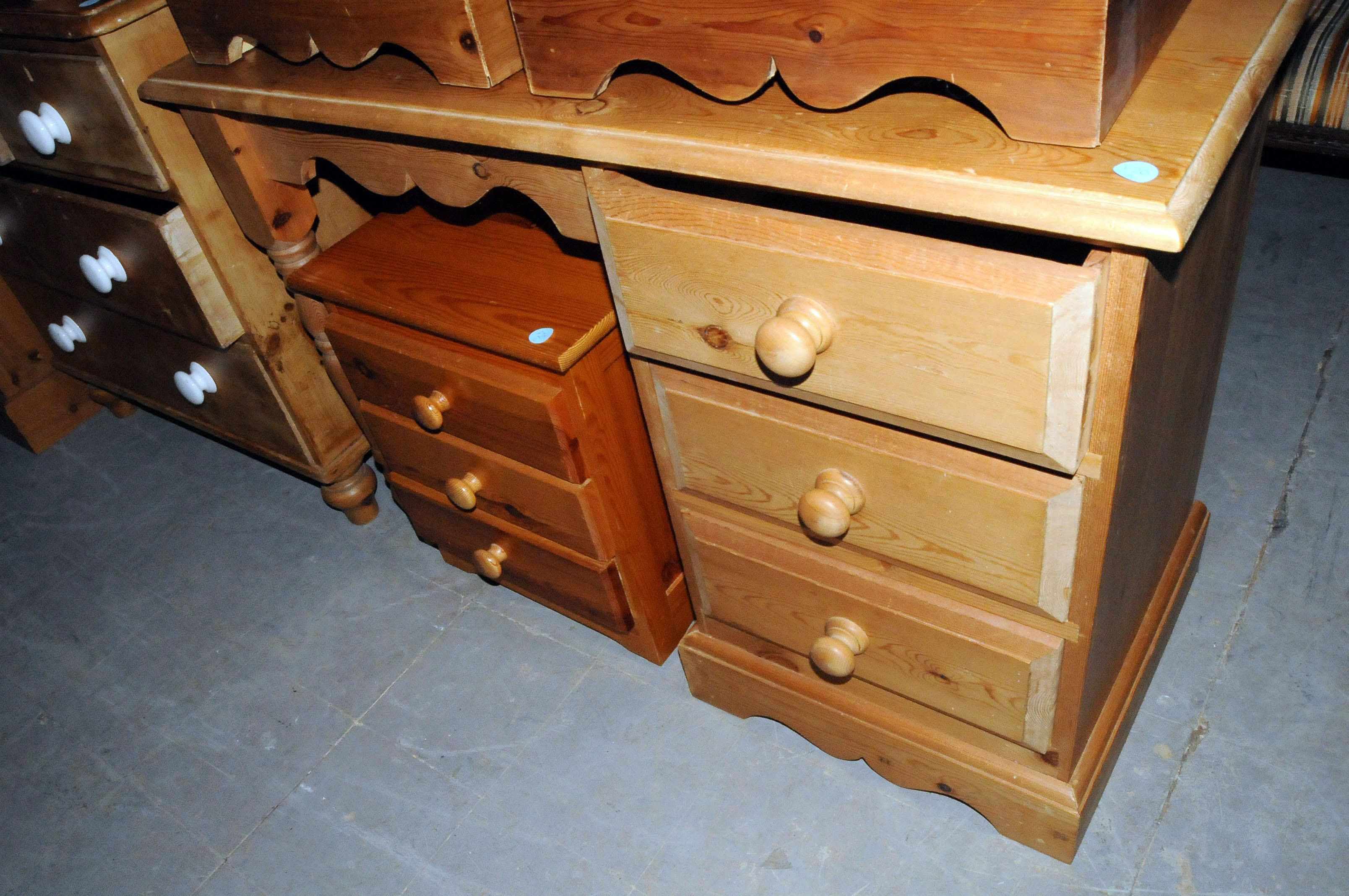 A pine desk, with a bank of drawers to one side and legs to the other, together with a small three