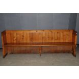A 19th century pine pew, with plank back surmounted by a moulded top rail 240cm W