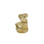 A rare German miniature Teddy Bear, possibly Bing, circa 1910, with golden mohair, black boot button