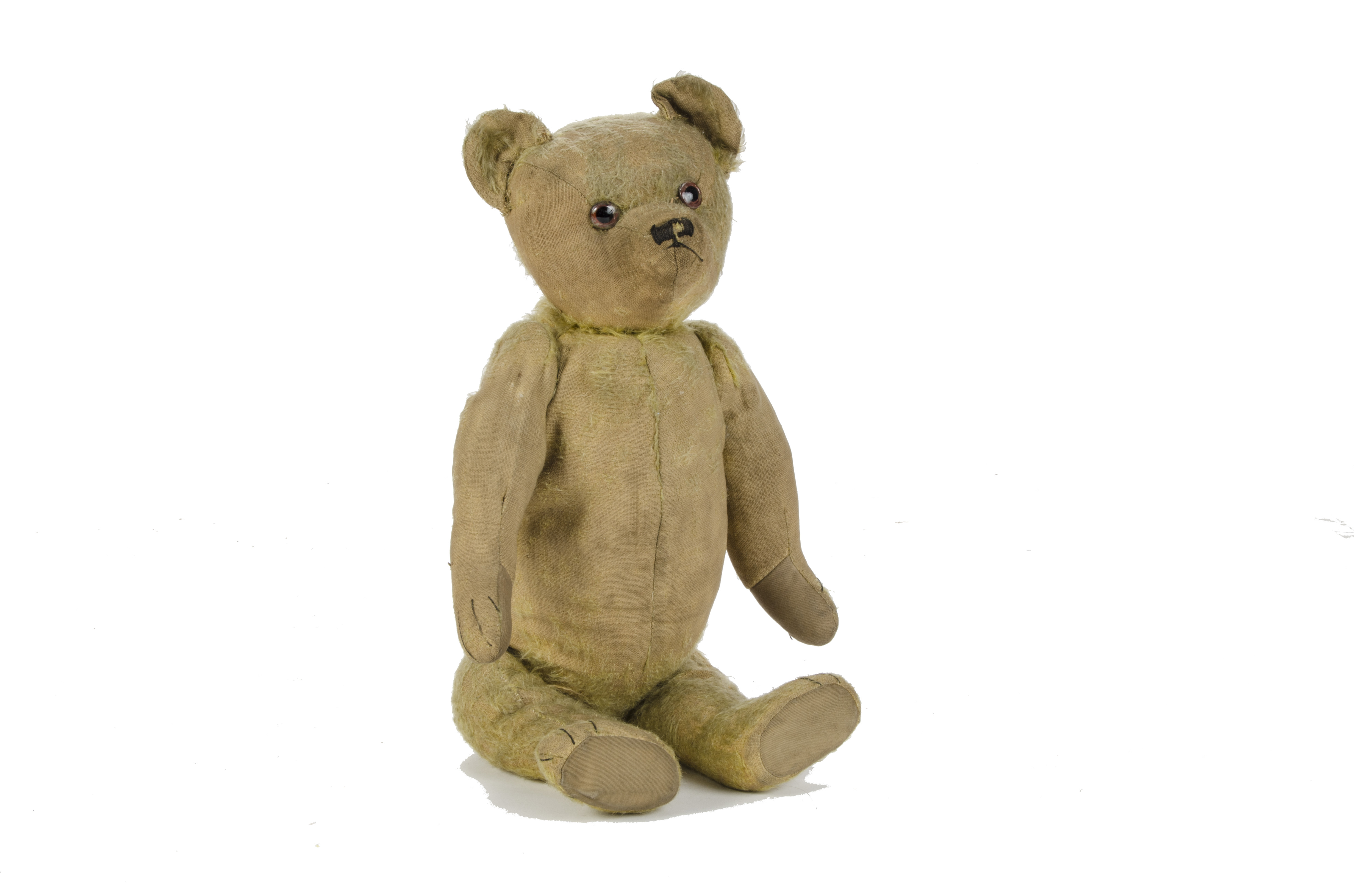 An early British Teddy Bear with chimes, 1920s, with golden mohair, clear and black glass eyes