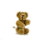 A Schuco miniature Teddy Bear with label, 1950s, with dark golden mohair, metal pin eyes, black