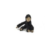 A rare Farnell black mohair ‘soldier’ monkey, circa 1920, with orange and black glass eyes, felt