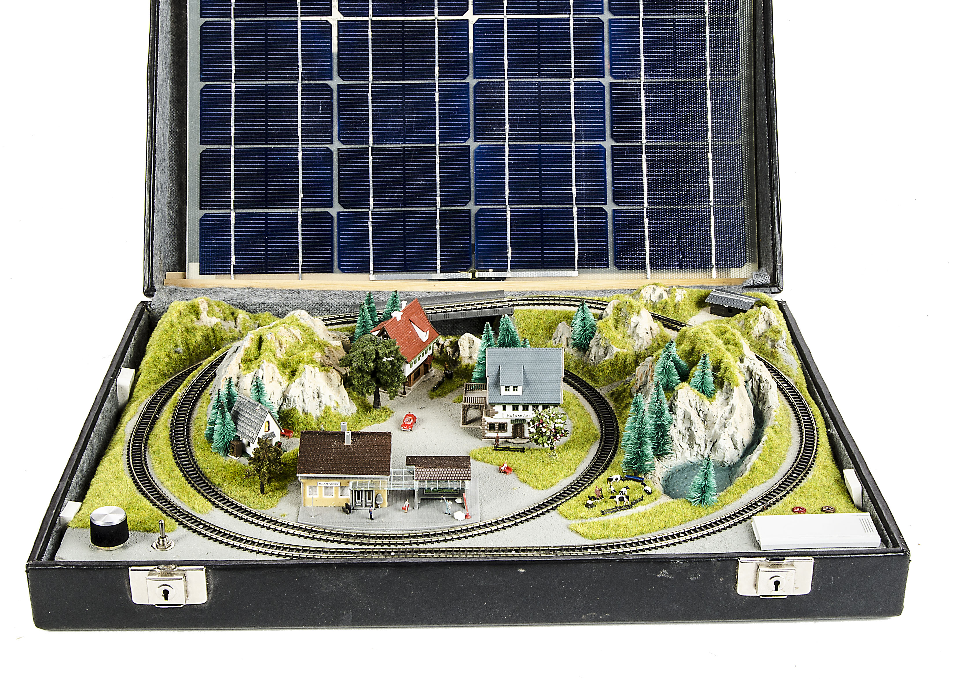 A Z Gauge solar-powered layout in a black briefcase 14”x19”x4”: a continental summer scene with