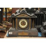 A Victorian black slate mantel clock wit