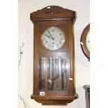 An oak cased wall clock with a silvered