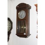 An oak wall clock with a slivered dial a