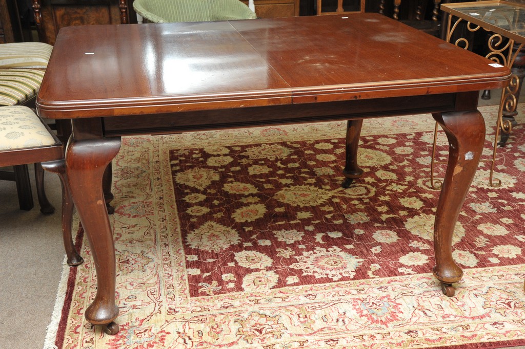 A walnut extending dining table with a s