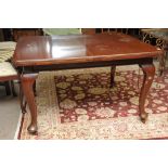 A walnut extending dining table with a s