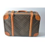A Louis Vuitton leather bound suitcase with usual logo pattern and fabric lined interior.