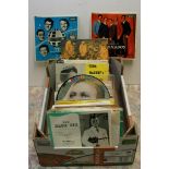 A box containing a collection of 45 rpm records including The Tornados,