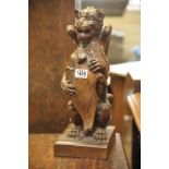 A carved oak late 19th Century gargoyle holding a shield