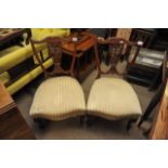 A pair of Edwardian mahogany nursing chairs with carved back splats and upholstered seats.