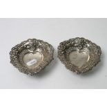 Two silver heart shaped dishes with pierced rims,