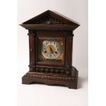 An oak cased mantle clock having square brass dial and silvered chapter ring with Arabic numerals