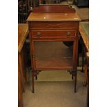An Edwardian cabinet with a single drawer above a glazed cupboard and raised on square tapering