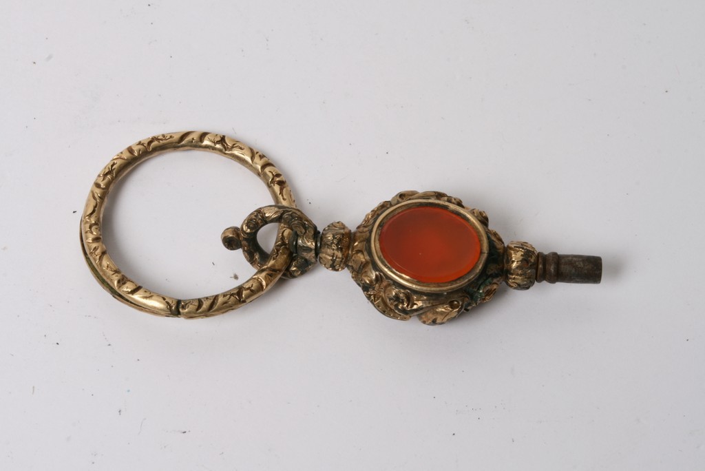 An antique watch key inset with cut and polished stones