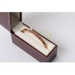 A quality 9ct gold bangle set with graduating Ruby's and diamonds