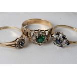 A gold ring inset with a green coloured stone and two blue sapphire and chip diamond rings