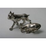 A silver model of a cow and a silver coated model of a dog