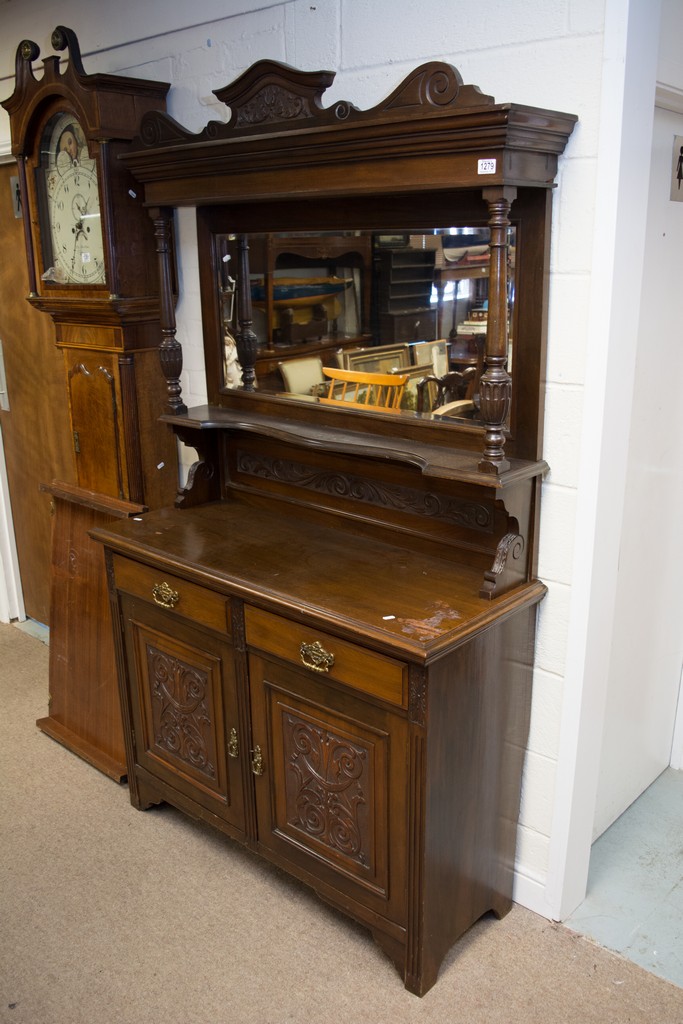 An Edwardian chiffonier fitted two drawers over two heavily carved cupboard doors.