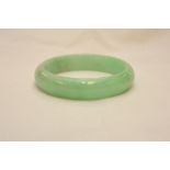 A pale green jadite bangle, 7.