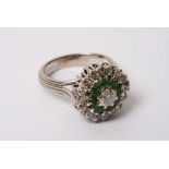 A 18ct white gold diamond and emerald set cluster ring