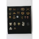 A collection of 23 various military badges including sleeve trade badges and some retrospective