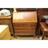 A walnut bureau fitted three drawers.