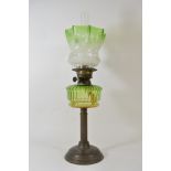 A Victorian oil lamp with green glass shade