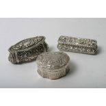 Three silver trinket boxes with scrolled and figural decoration,