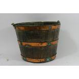 An oak copper bound bucket with brass swing handle