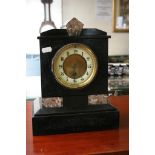 A black slate mantle clock with marble motifs.