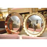 Two convex mirrors, one having pink coloured surround.