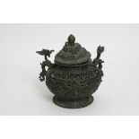 A cast metal Chinese censer with detachable lid with applied dragon handles and pierced body.