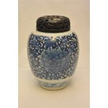 A 20th century Chinese blue and white vase with a carved hardwood cover,