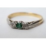 An 18ct gold ring set with diamonds and a single emerald