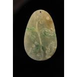 A jade oval pendant carved with stylized fish