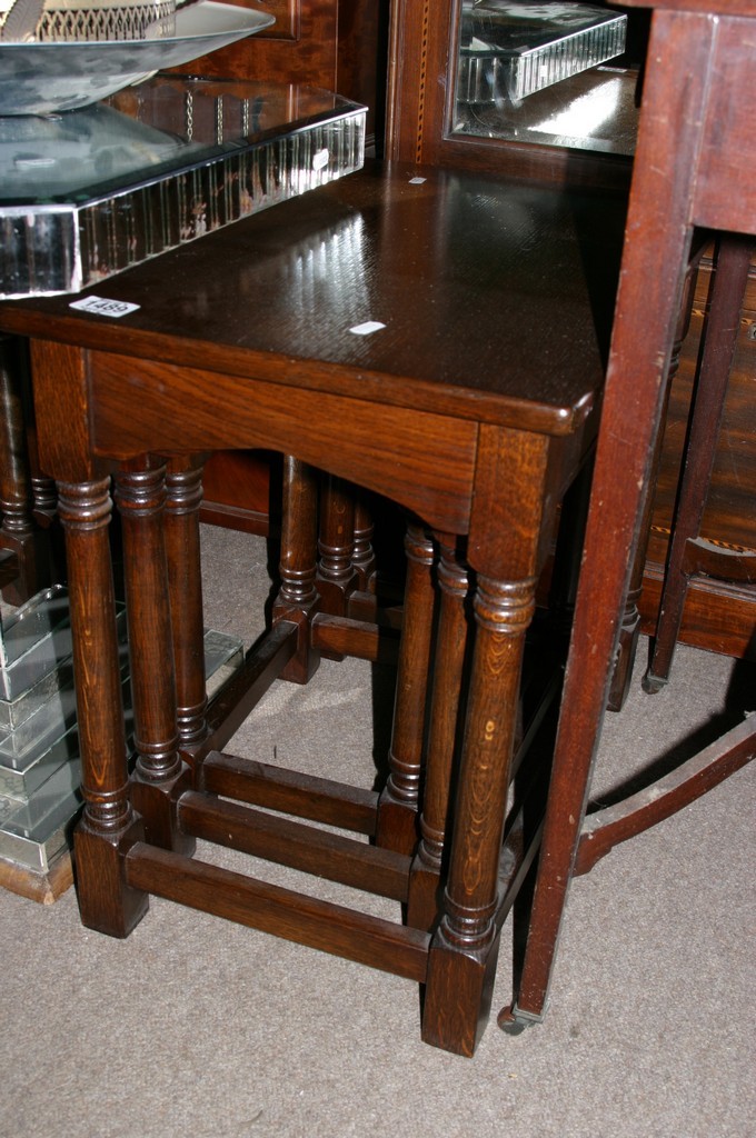 A nest of three oak occasional tables with rectangular tops