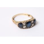 A vintage gold ring set with a row of sapphires and diamonds,