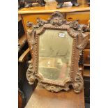 A late 19th century carved oak wall mirror with scroll decoration and a beveled edge plate