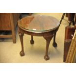 A Walnut circular occassional table with ball and claw feet.