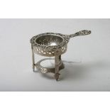 An attractive silver strainer and stand,