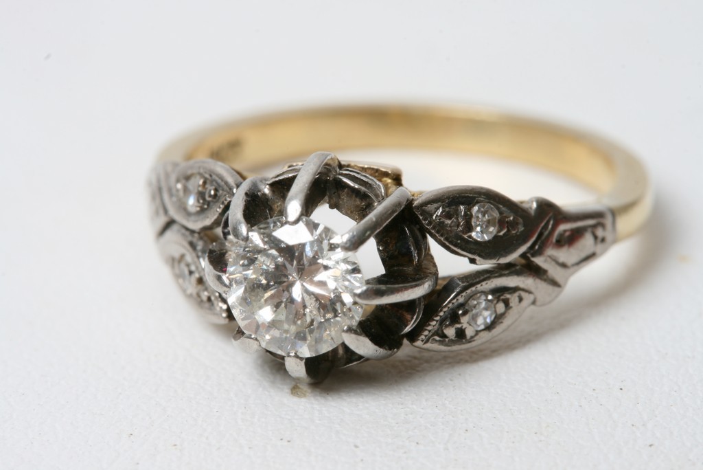 Withdrawn An 18ct gold ring set with a single diamond and diamond chip shanks