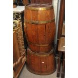 A carved oak drinks cabinet in the form of an oval brass bound barrel with a conforming base