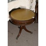 An antique leather topped circular drum table fitted three drawers and three faux drawers.