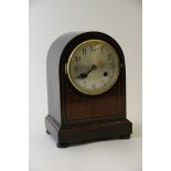 A mahogany mantel clock, the silvered dial with Arabic numerals,