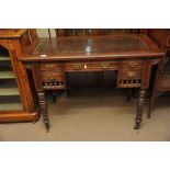 An Edwardian walnut desk the leather lined top above draws on turned legs