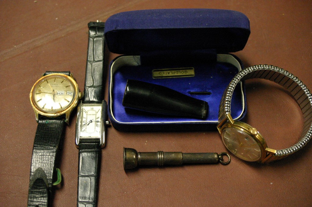 A silver cigar cutter and three gent's wristwatches