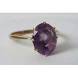 A 9ct gold ring set with a purple stone