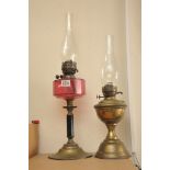 A Victorian cranberry glass oil lamp and one other brass oil lamp (2)